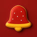 Red and yellow bell-shaped cookie on a red background from a 2.25 inch Bell Metal Cookie Cutter