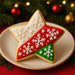 2.5 inch Star Metal Cookie Cutter decorated cookie on a plate with red, white, and green icing and snowflake designs.