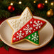 2.5 inch Star Metal Cookie Cutter decorated cookie on a plate with red, white, and green icing and snowflake designs.