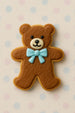 Brown teddy bear cookie with a blue bow tie on a polka dot background from a 4 inch Teddy Bear Metal Cookie Cutter