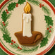 4 inch Candle Metal Cookie Cutter shaped cookie on a festive plate with holly and pine decoration.