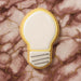 4.5 inch Light Bulb Metal Cookie Cutter shaped cookie on marble surface background.