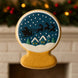3.5 inch Snow Globe Metal Cookie Cutter shaped cookie with a holiday design featuring Santa and reindeer.