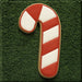 Candy cane-shaped cookie on a green textured background from a 5 inch Candy Cane Metal Cookie Cutter