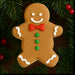 Decorative gingerbread man cookie with a red bow tie on a green leaf background from a 3.5 inch Gingerbread Boy Metal Cookie Cutter