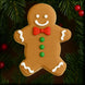 Decorative gingerbread man cookie with a red bow tie on a green leaf background from a 3.5 inch Gingerbread Boy Metal Cookie Cutter