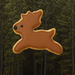 3 inch Reindeer Metal Cookie Cutter shaped cookie decorated with frosting against a forest background.