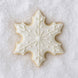 Decorative snowflake cookie with white icing on a textured white background from a 3 inch Snowflake Metal Cookie Cutter