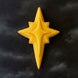 Yellow star-shaped object on a black background from a 3.5 inch Star of Bethlehem Moravian Star Metal Cookie Cutter