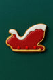 4.75 inch Santa's Sleigh Metal Cookie Cutter decorated cookie on green background.