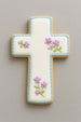 Decorative cross-shaped cookie with floral designs on a gray background from a 4 inch Cross Metal Cookie Cutter