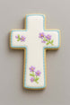 Decorative cross-shaped cookie with floral designs on a gray background from a 4 inch Cross Metal Cookie Cutter