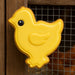 Yellow chick-shaped cookie on a wooden surface with a wire mesh background from a 2.5 inch Chick Metal Cookie Cutter