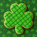 Green plaid shamrock cookie on a green background with shamrock patterns from a 3 inch Shamrock Metal Cookie Cutter