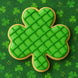 Green plaid shamrock cookie on a green background with shamrock patterns from a 3 inch Shamrock Metal Cookie Cutter