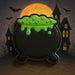 Halloween-themed cookie shaped like a black cauldron with green gooey filling, set against a dark background with bats and a haunted house from a 3.5 inch Pot O Gold or Witch's Cauldron Metal Cookie Cutter