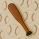 Cookie cutter shaped like a baseball bat on a background with baseball patterns from a 4.5 inch Baseball Bat Metal Cookie Cutter