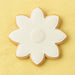 Decorative cookie shaped like a flower with white icing on a yellow background from a 2.25 inch Mini Daisy Flower Metal Cookie Cutter