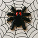 2.5 inch Spider Metal Cookie Cutter shaped black spider cookie with red eyes on spider web background.