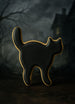 Black cat-shaped cookie with gold accents on a dark background from a 3 inch Witch's Cat Metal Cookie Cutter