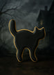 Black cat-shaped cookie with gold accents on a dark background from a 3 inch Witch's Cat Metal Cookie Cutter