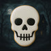 Skull-shaped cookie with a dark background featuring a moon and trees from a 3 inch Skull Metal Cookie Cutter