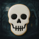 Skull-shaped cookie with a dark background featuring a moon and trees from a 3 inch Skull Metal Cookie Cutter