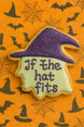 Halloween-themed witch head cookie with a purple witch hat and 'If the hat fits' text on an orange background with spider webs and bats from a 4 inch Witch Head Metal Cookie Cutter