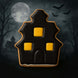 Halloween-themed cookie shaped like a haunted house with black icing and yellow squares on a dark background from a 3.5 inch Haunted House Metal Cookie Cutter