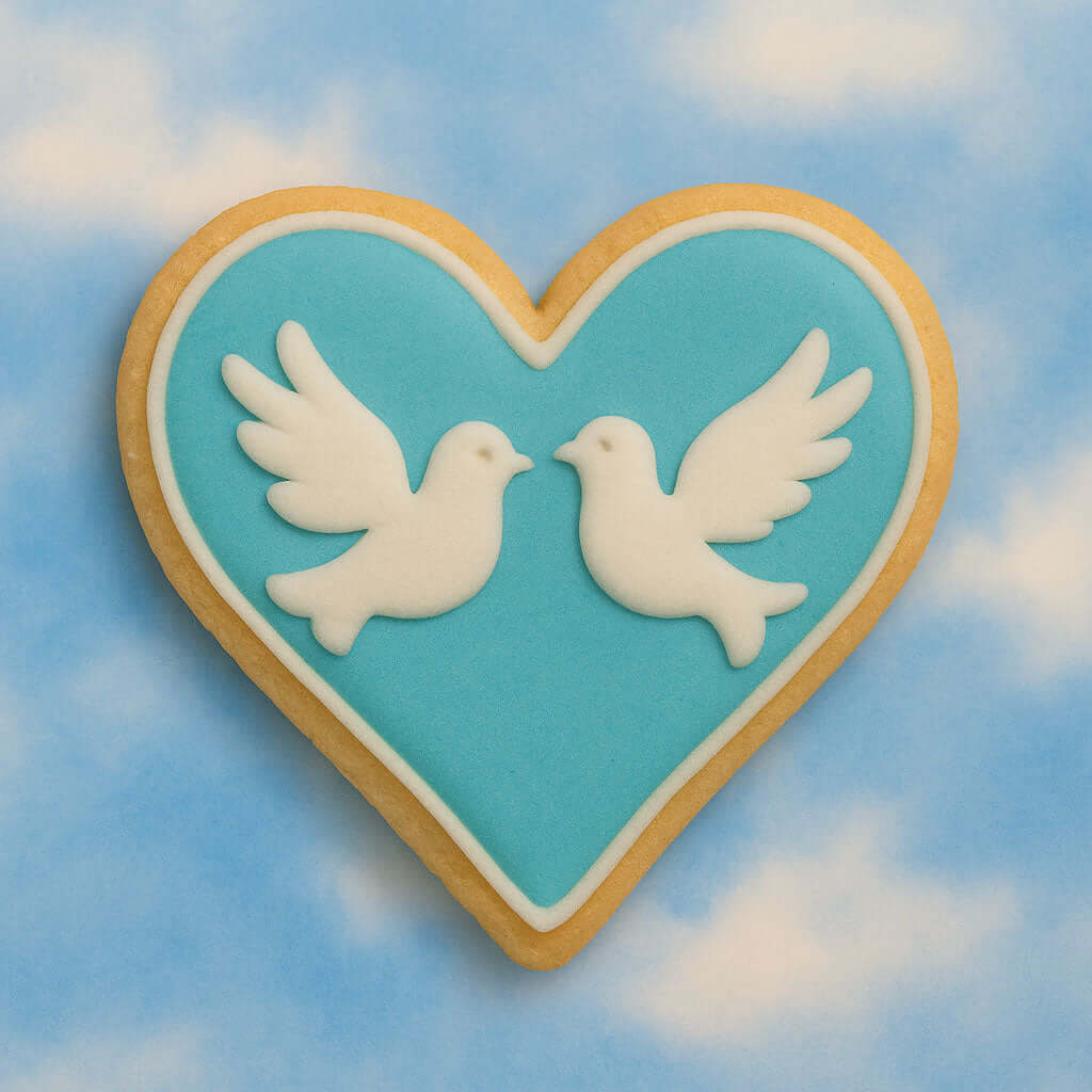 Heart-shaped cookie with two white doves on a blue sky background from a 2 inch Heart Metal Cookie Cutter