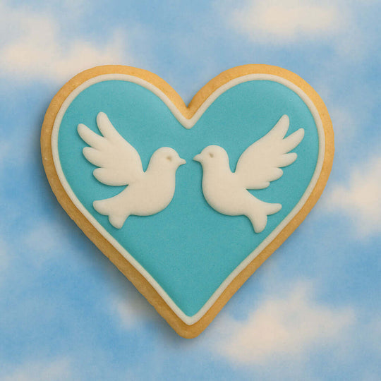 Heart-shaped cookie with two white doves on a blue sky background from a 2 inch Heart Metal Cookie Cutter