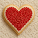 Heart-shaped cookie with red floral design on a textured beige background from a 1.75 inch Mini Heart Metal Cookie Cutter