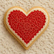 Heart-shaped cookie with red floral design on a textured beige background from a 1.75 inch Mini Heart Metal Cookie Cutter