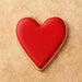Heart-shaped cookie with red icing on a beige background from a 2.75 inch Heart Metal Cookie Cutter