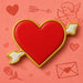 Heart-shaped cookie with gold border on a pink background with heart and arrow illustrations from a 4.75 inch Heart with Arrow Metal Cookie Cutter