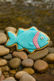 Fish-shaped cookie with blue icing and pink interior on pebbles near water from 5 inch Fish Metal Cookie Cutter