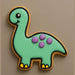 Brontosaurus-shaped cookie with green body, purple spots, and yellow feet on a beige background from a 4 inch Brontosaurus Metal Cookie Cutter