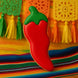 Red chili pepper-shaped cookie on a colorful background with tassels from a 5 inch Chili Pepper Metal Cookie Cutter
