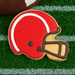 Cookie shaped like a football helmet on grass with a football in the background from a 4.5 inch Football Helmet Metal Cookie Cutter