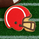 Cookie shaped like a football helmet on grass with a football in the background from a 4.5 inch Football Helmet Metal Cookie Cutter