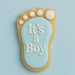 Decorative cookie shaped like a baby footprint with 'It's a Boy' text on a light blue background from a 3.5 inch Left Foot Metal Cookie Cutter