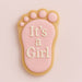 Decorative cookie shaped like a baby footprint with 'It's a Girl' text on a pink background from a 3.5 inch Left Foot Metal Cookie Cutter
