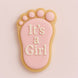 Decorative cookie shaped like a baby footprint with 'It's a Girl' text on a pink background from a 3.5 inch Left Foot Metal Cookie Cutter