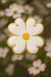 Decorative flower-shaped cookie with white icing and yellow center against a blurred floral background from a 3 inch Dogwood Blossom Metal Cookie Cutter