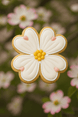 Decorative flower-shaped cookie with white icing and yellow center against a blurred floral background from a 3 inch Dogwood Blossom Metal Cookie Cutter