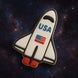 Space shuttle cookie with 'USA' and American flag on a space-themed background from a 4.5 inch Space Shuttle Metal Cookie Cutter