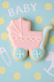 Cookie shaped like a baby stroller on a blue background with polka dots and 'BABY' text from a 4 inch Baby Carriage Metal Cookie Cutter