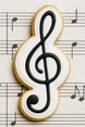 Cookie shaped like a g clef on sheet music from a 4 inch G Clef Metal Cookie Cutter