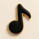 Cookie shaped like a black musical note on a beige background from a 5 inch Music Note Metal Cookie Cutter