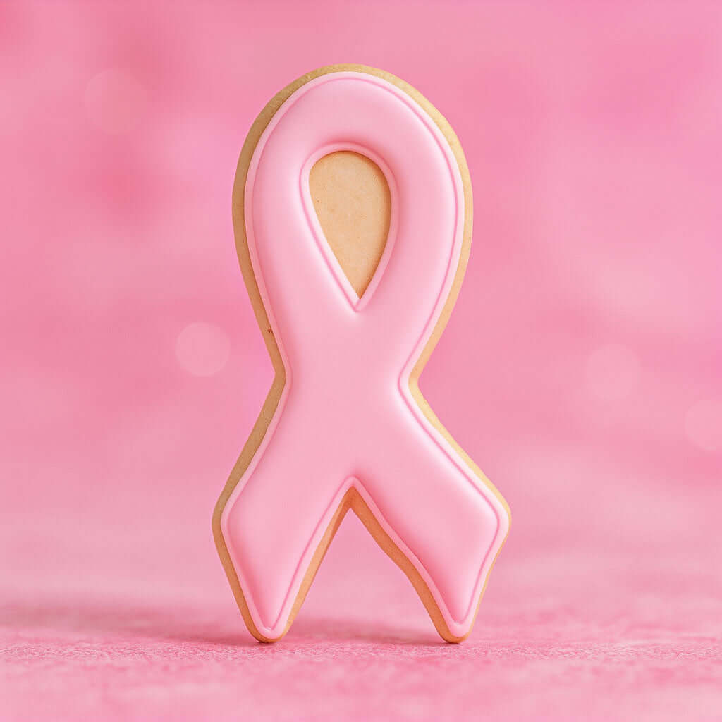 3.75 inch Awareness Ribbon Metal Cookie Cutter shaped pink cookie on a pastel pink background.